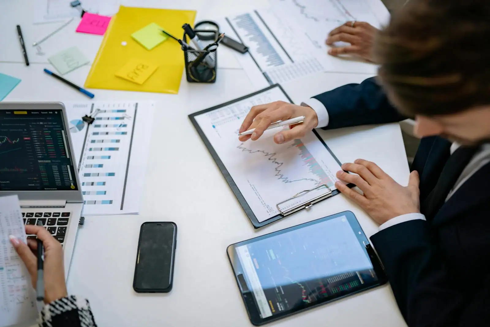 Équipe d'agence digitale en réunion autour d'un tableau blanc et de graphiques de performance