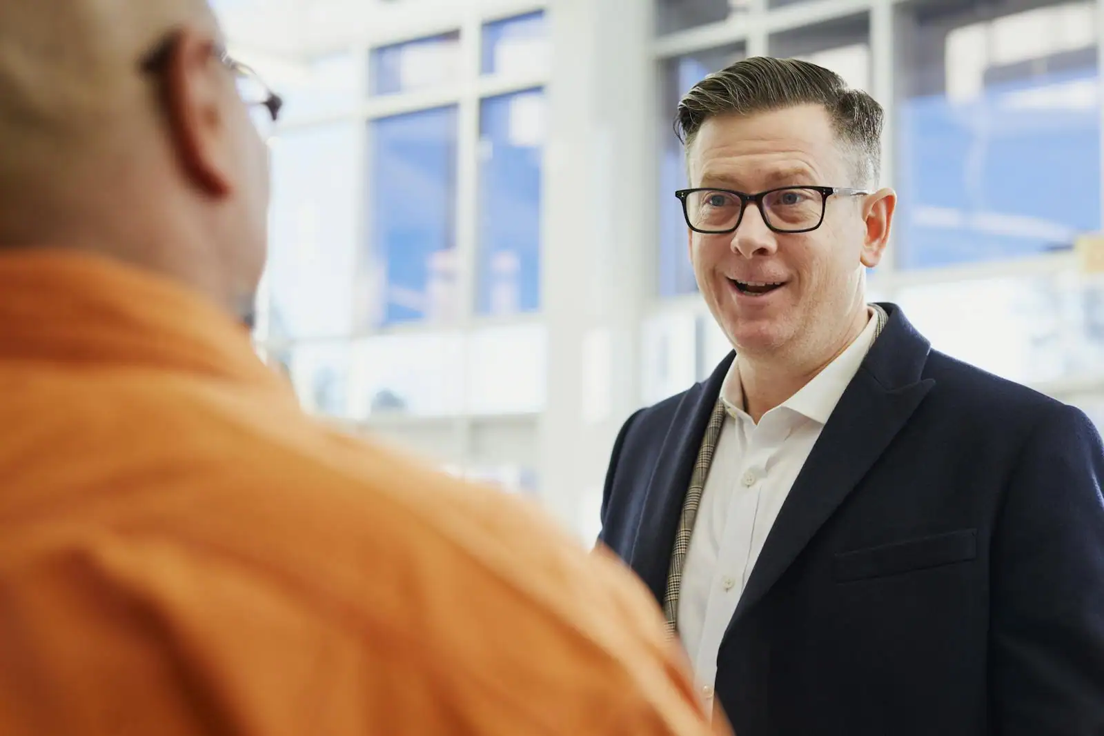 Deux collègues en conversation professionnelle, gestes et expressions visibles