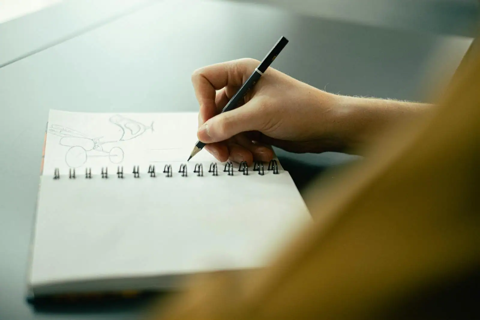 Bureau de designer graphique avec carnet de croquis, propositions de logos en noir et blanc et palette de couleurs