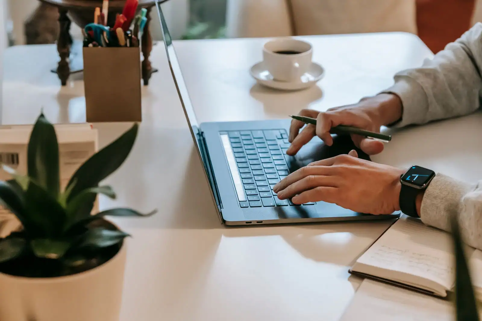 Travailleur indépendant à son ordinateur portable dans un espace de travail à domicile.