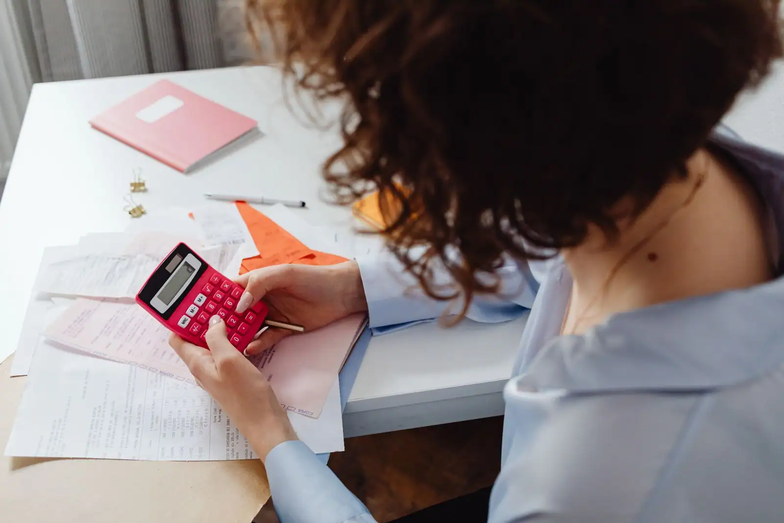 Freelance calculant son taux journalier moyen sur un ordinateur portable et une calculatrice
