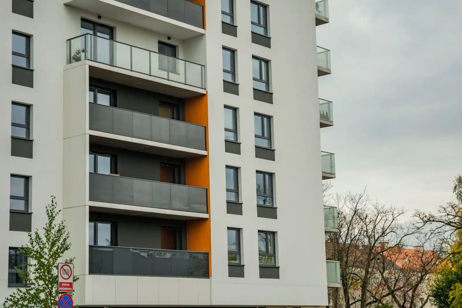 Immeuble résidentiel moderne avec balcons, vu depuis la rue par une journée claire