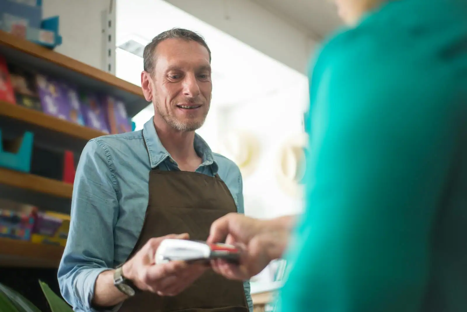 Manager commercial en point de vente en train de débriefer un collaborateur sur une tablette
