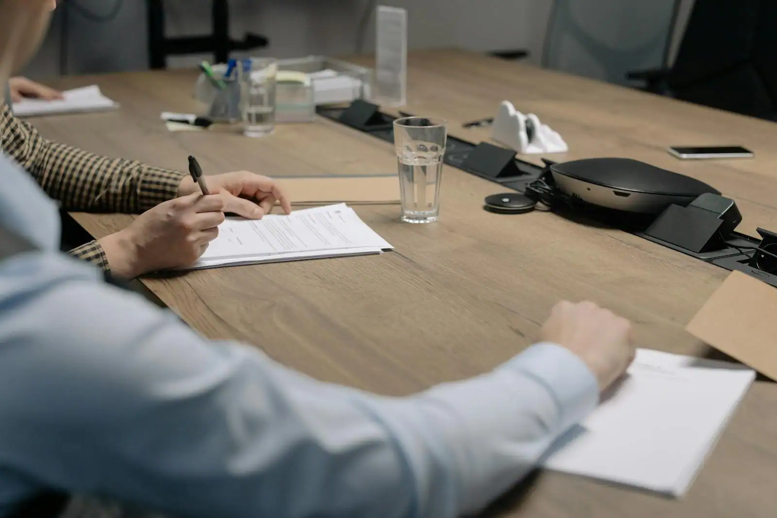Salle de réunion d'affaires avec contrats et tableurs financiers, discussion d'investissement non coté