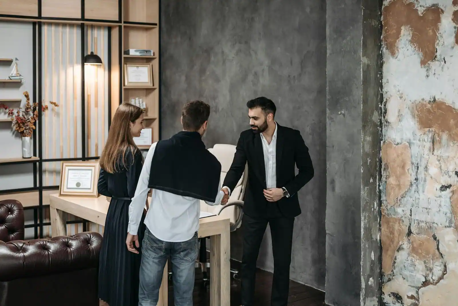 Commercial et client se serrant la main lors d'un rendez-vous de vente autour d'une table de réunion