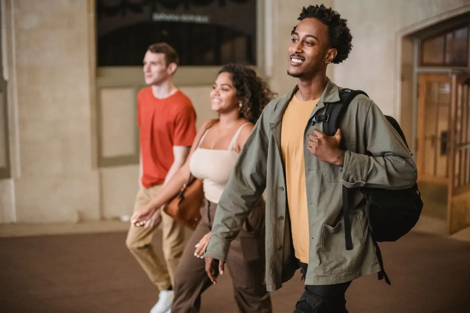 Trois étudiants avec sacs à dos marchant ensemble, illustrant la mobilité étudiante internationale.