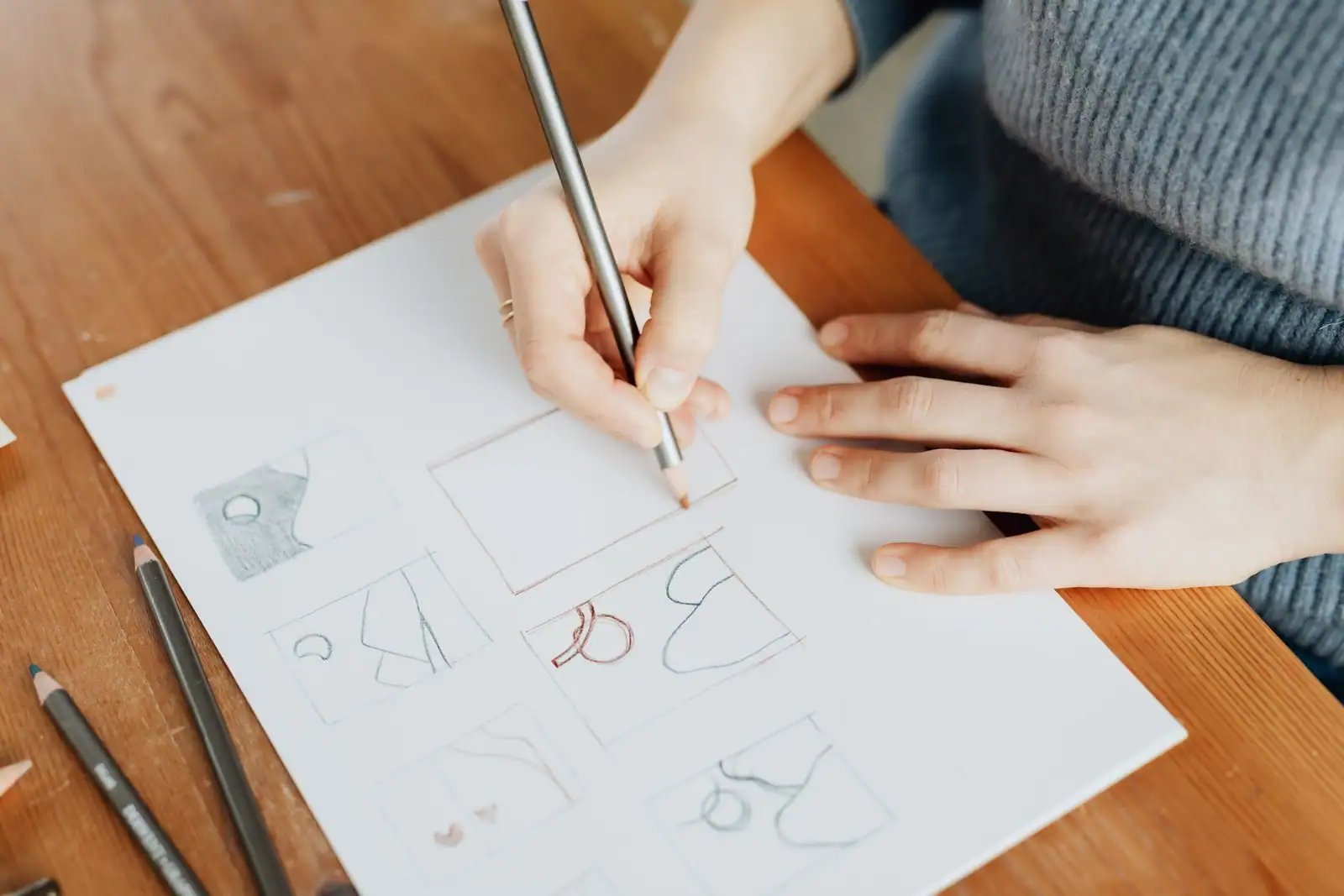 Croquis de concepts graphiques au crayon sur une feuille, lors d'une phase de recherche créative