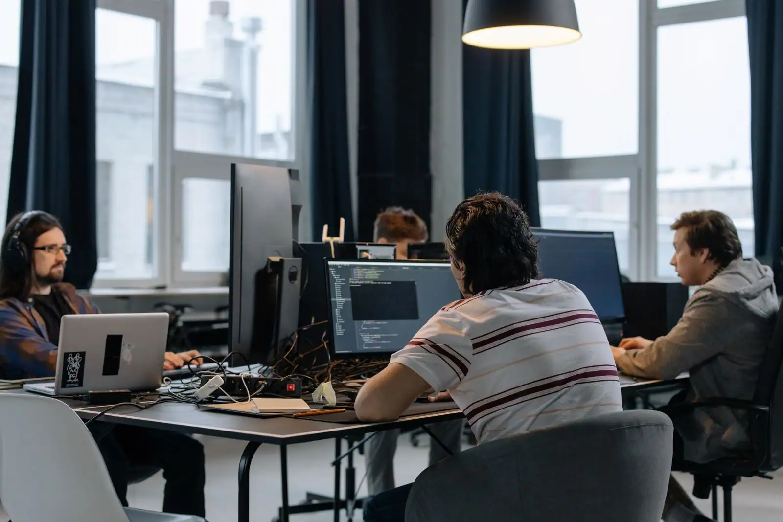 Développeur travaillant devant un écran affichant du code, dans un bureau partagé