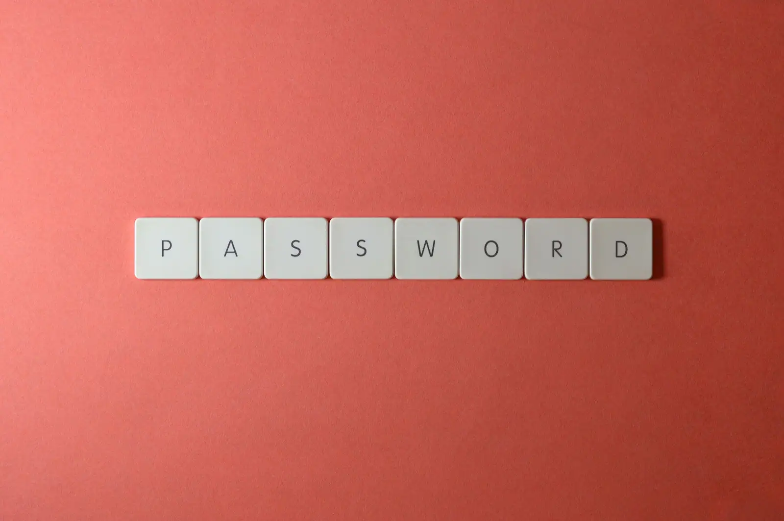 Des touches de clavier blanches forment le mot « password » sur un fond corail.