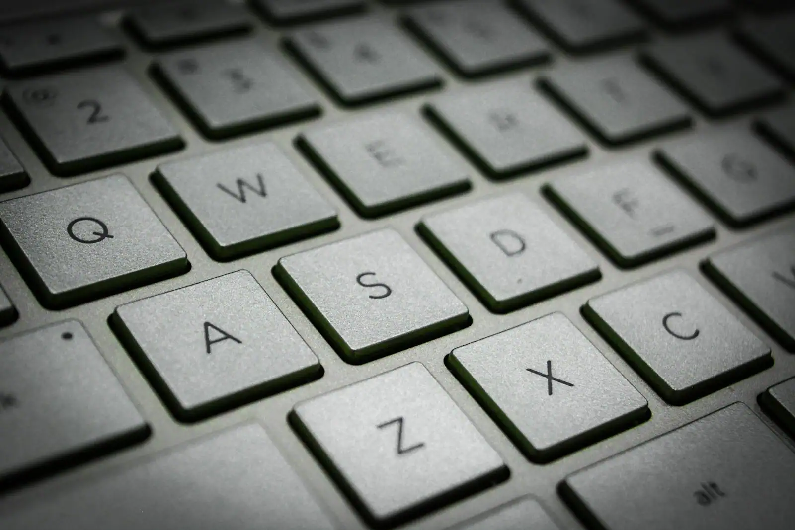 Gros plan sur les touches d'un clavier d'ordinateur, où se saisissent les mots de passe.