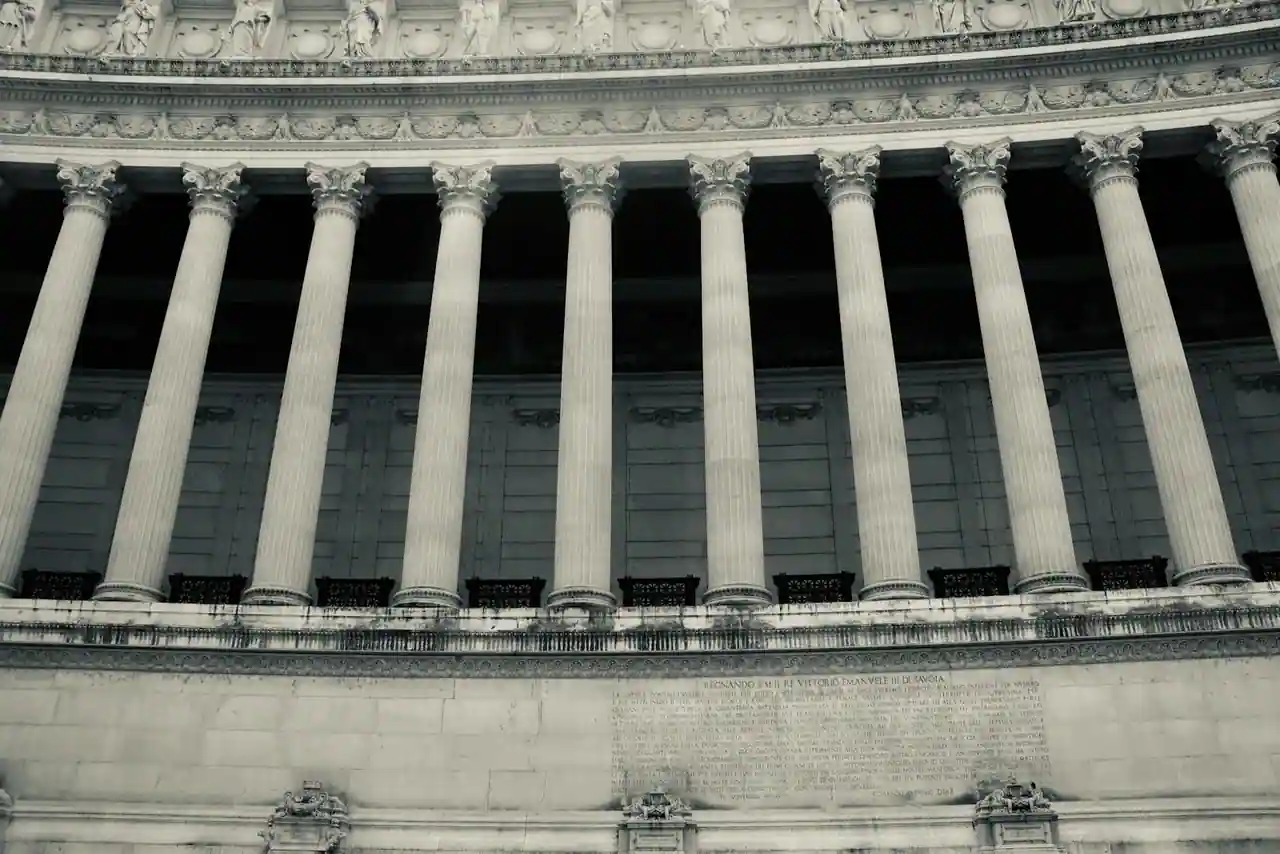 Colonnade en pierre d'un grand édifice classique, photographiée en contre-plongée