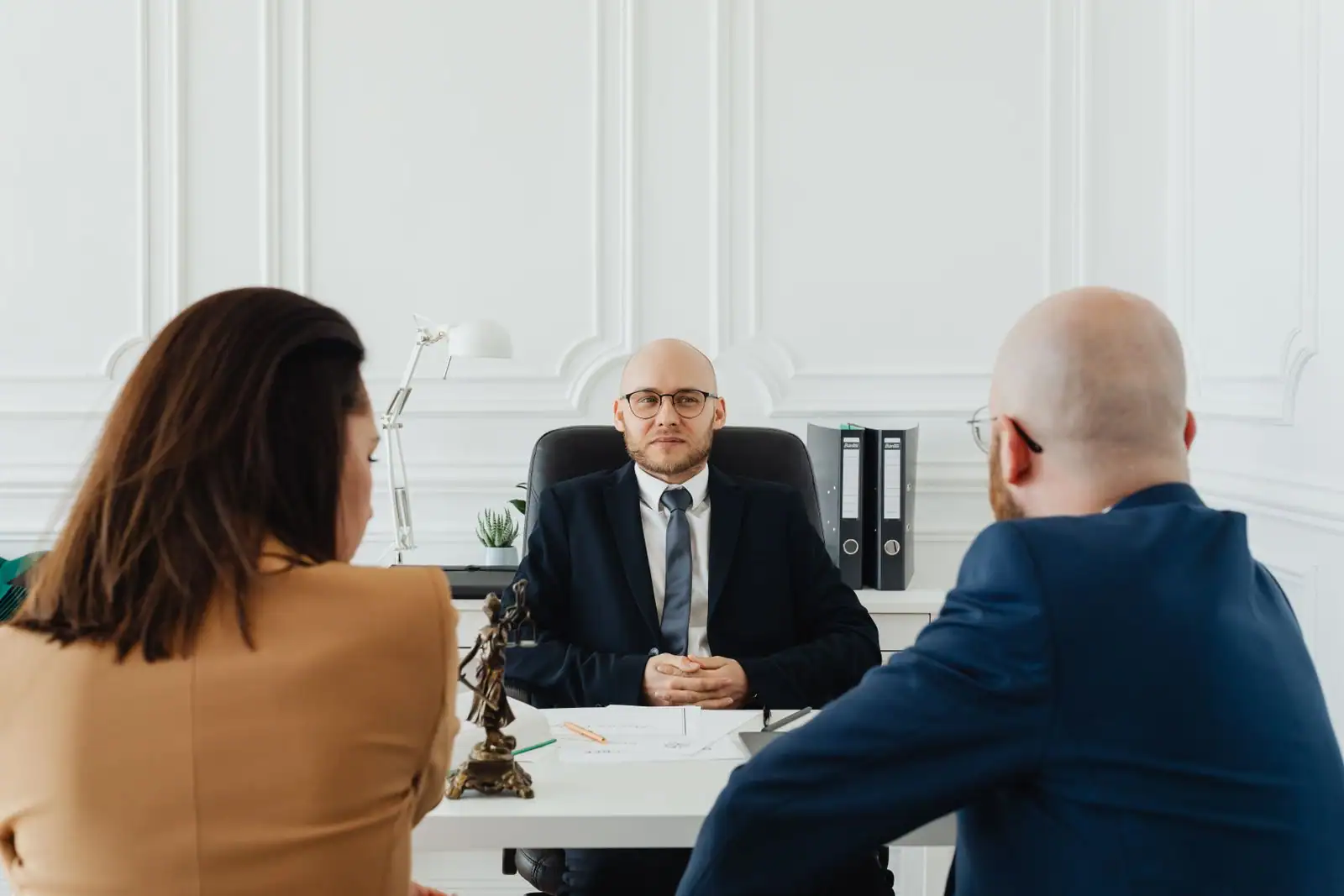 Entretien professionnel dans un bureau, une personne face à deux interlocuteurs.