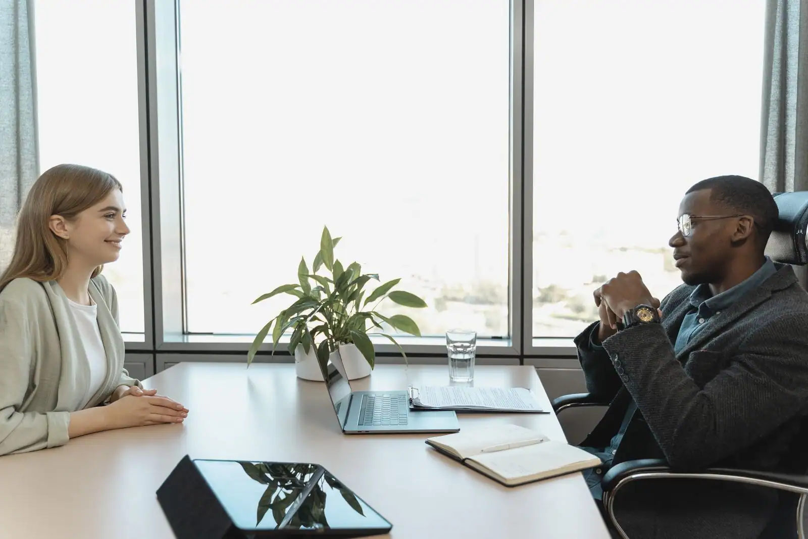Une candidate et un recruteur en entretien d'embauche, assis face à face à un bureau