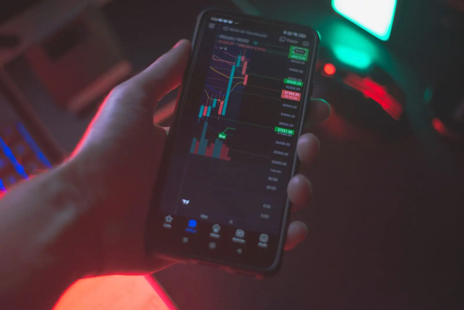 Écran de smartphone affichant des cours et graphiques de cryptomonnaies
