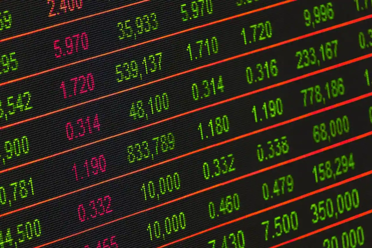 Écran de cotation boursière affichant des cours en vert et rouge, illustrant le marché des actions.