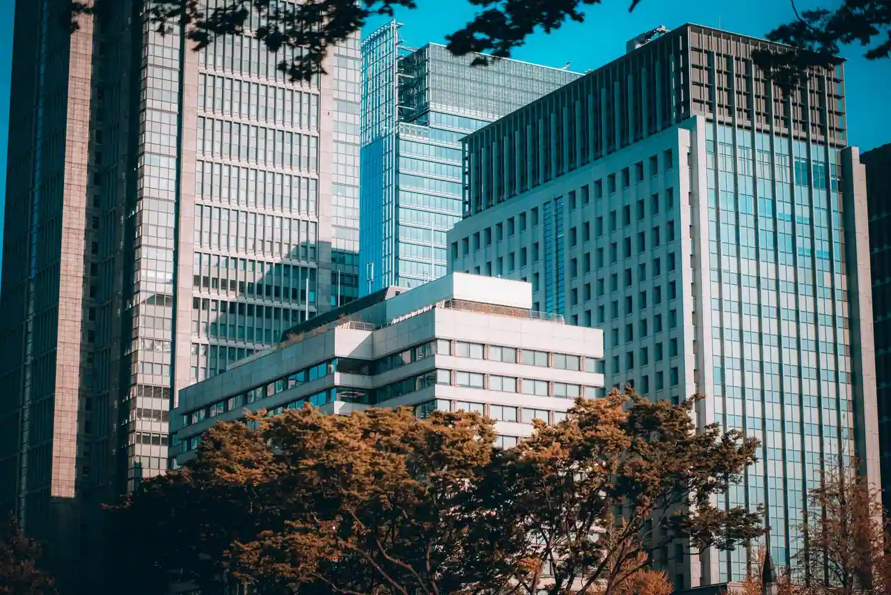 Gratte-ciel vitrés d'un quartier d'affaires moderne, évoquant l'univers des grandes places financières.