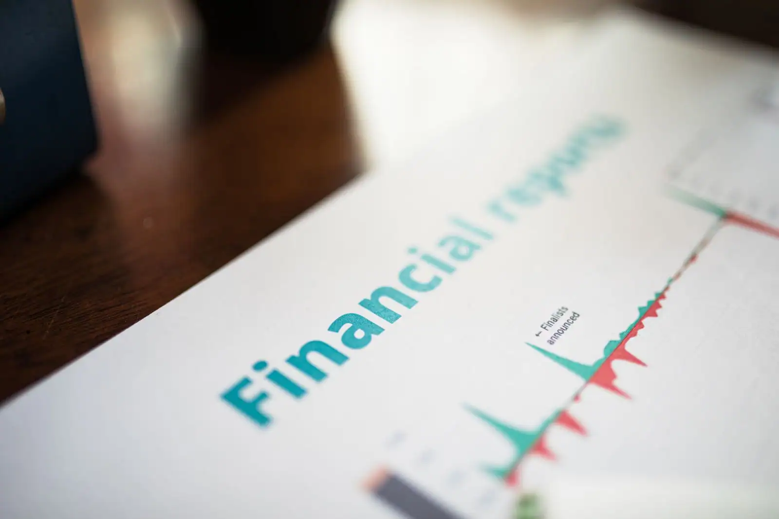 Un rapport financier imprimé présentant un graphique de marché, évoquant le suivi de l'actualité économique.