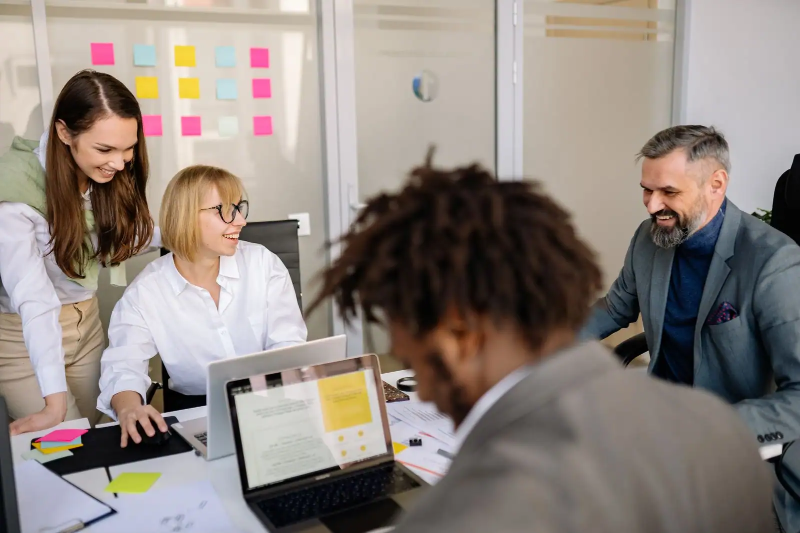 Équipe réunie autour d'une table de travail avec des notes et un tableau de planification