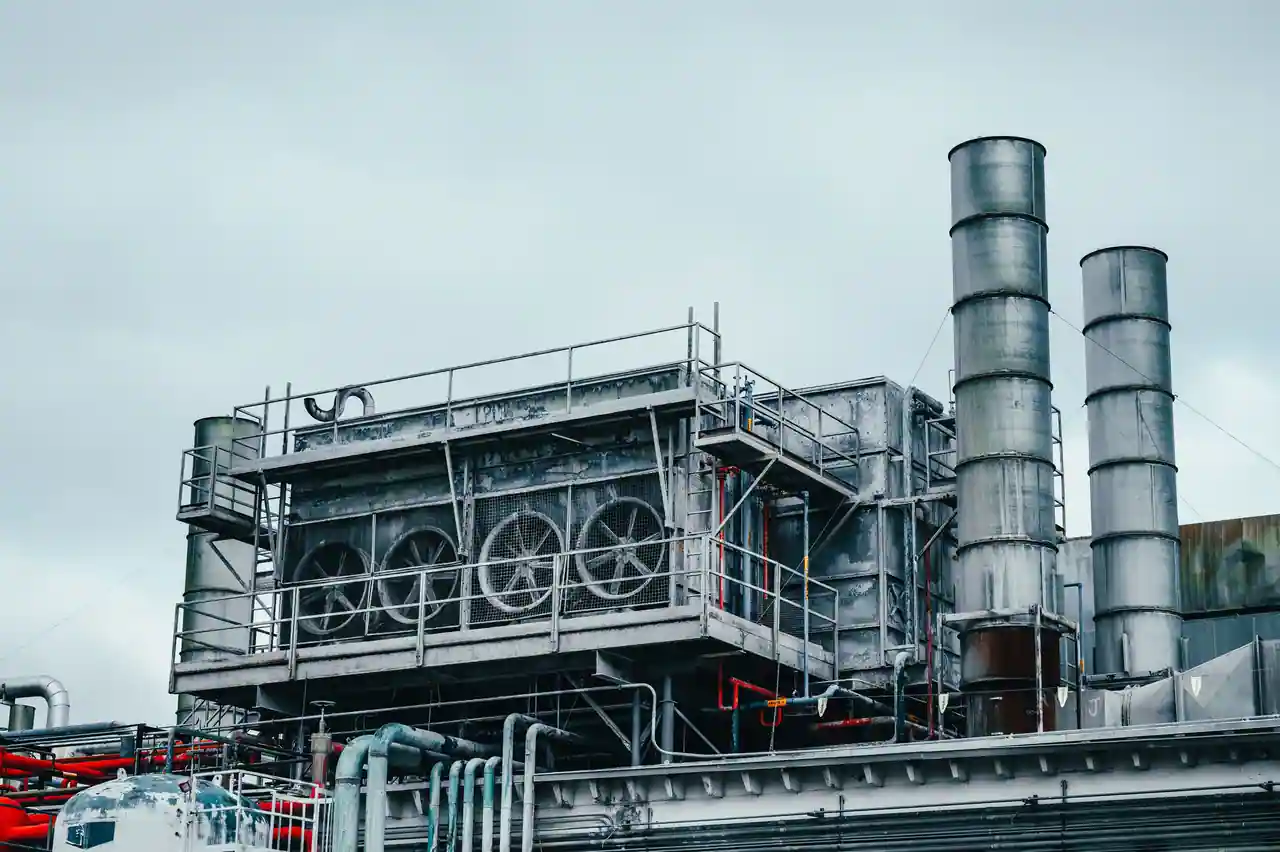 Installation industrielle en extérieur : batterie de ventilateurs, colonnes verticales et réseau de tuyauteries.