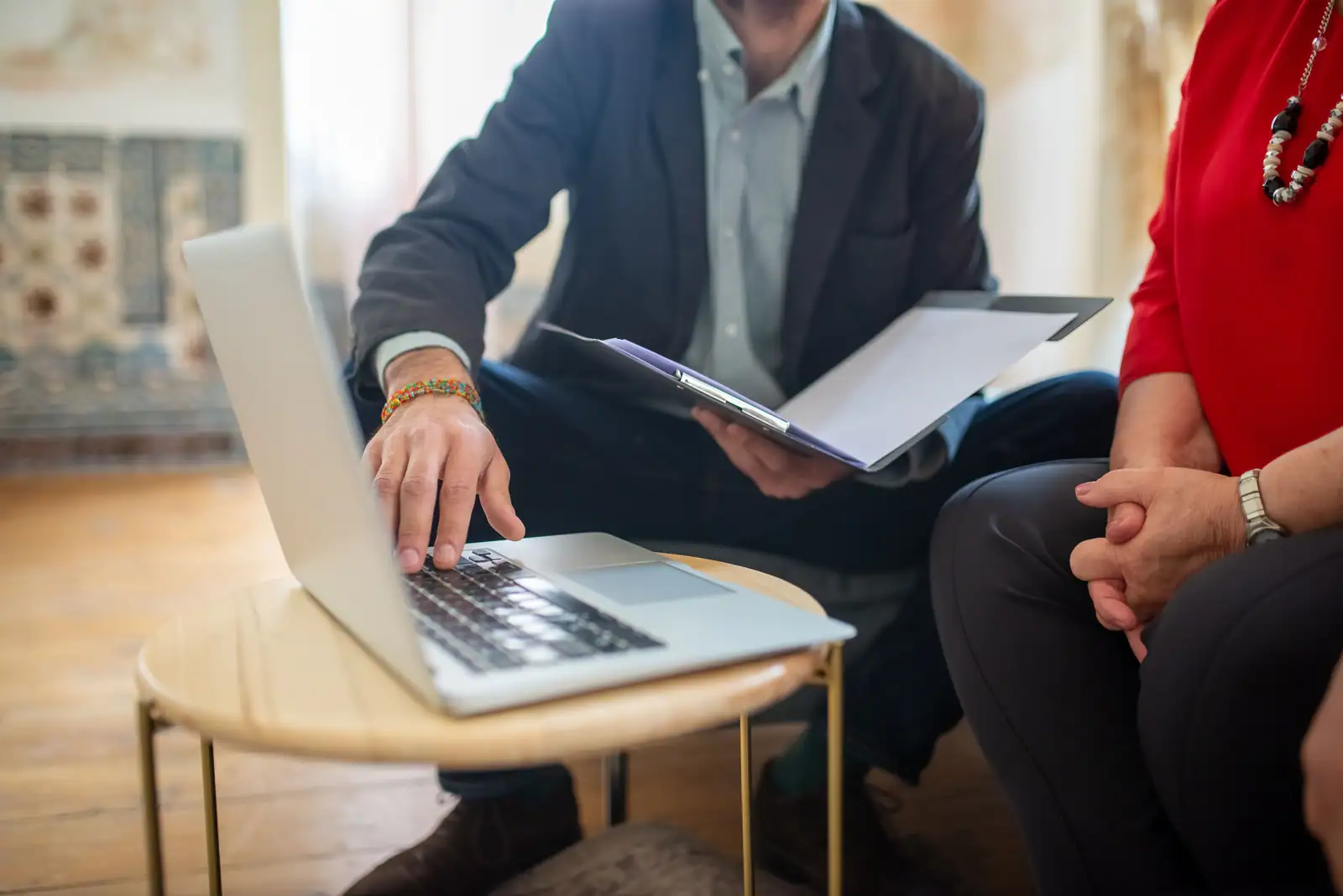 Un ordinateur portable ouvert sur une table basse pendant un rendez-vous de travail à deux.